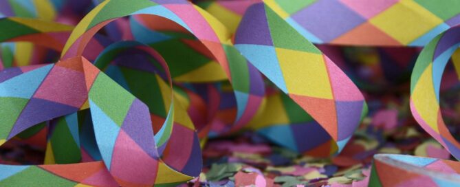 Konfetti und bunte Luftschlangen liegen durcheinander auf dem Boden.