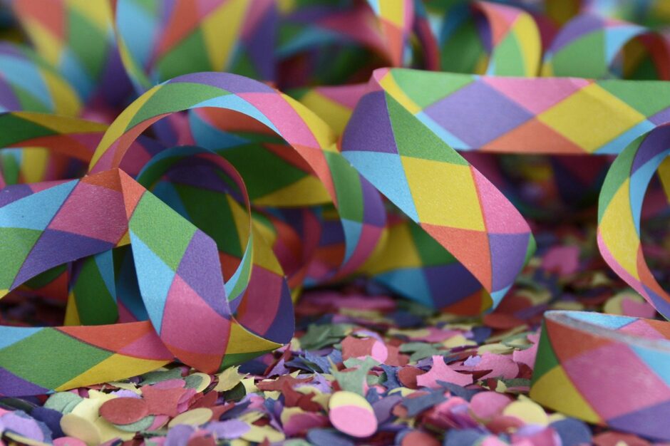 Konfetti und bunte Luftschlangen liegen durcheinander auf dem Boden.