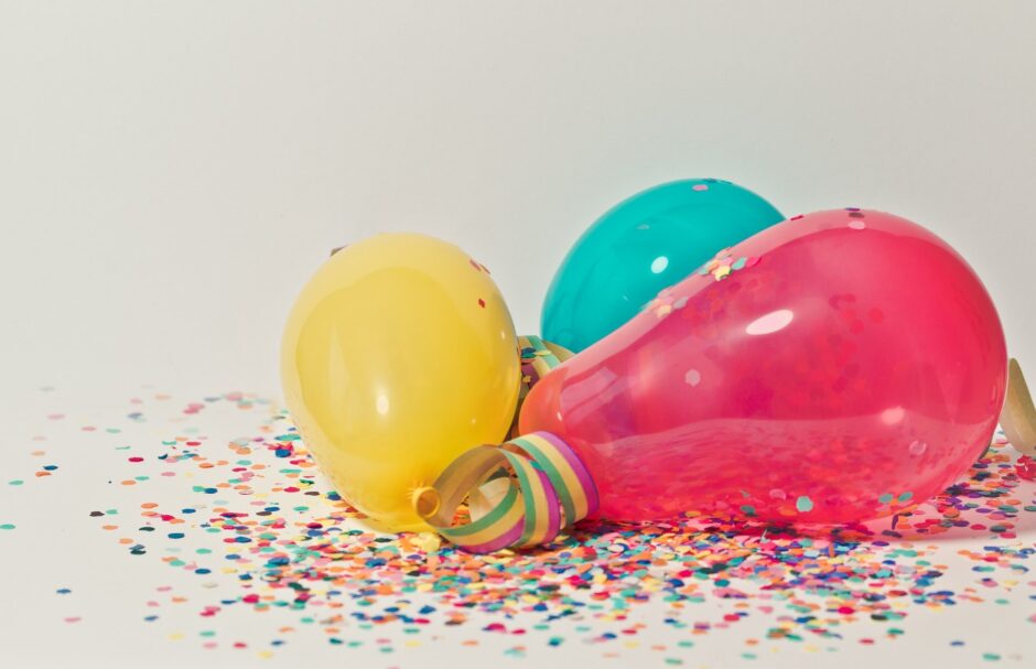 Luftballons liegen mit Konfetti auf dem Boden.