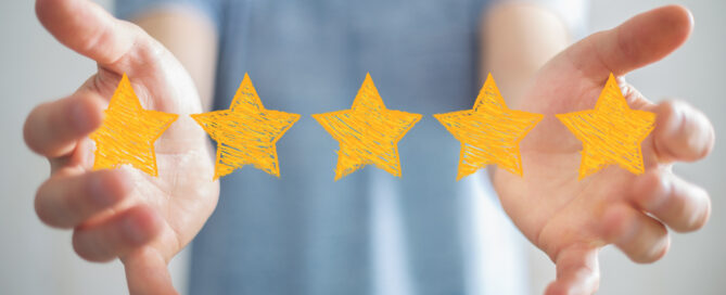 Zwei Hände halten grafisch erstellte fünf Sterne.