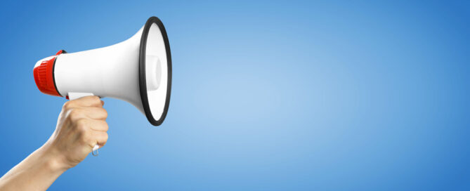 Eine hand hält ein Megaphone.