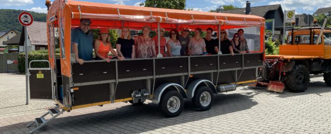 Ein Planwagen mit Menschen darin steht zur Abfahrt bereit.